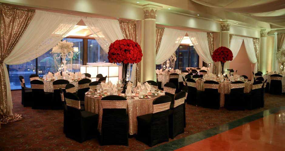 Black and gold table setup with tall red roses centerpieces. 