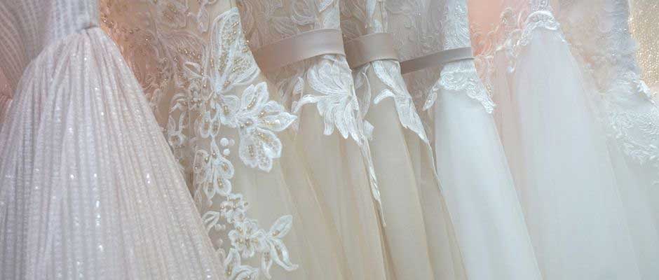 Photo of multiple bridal gowns. 