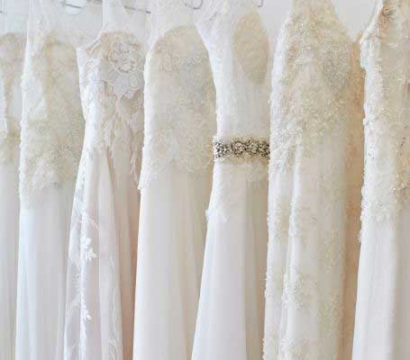 Photo of multiple wedding gowns. 