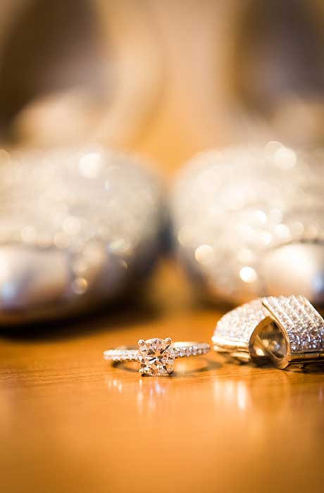 A close up of the brides engagement ring with her bridal shoes blurred in the background.