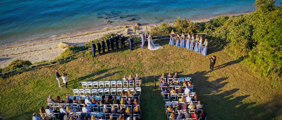 Aerial view of the wedding ceremony and guest over looking the water.