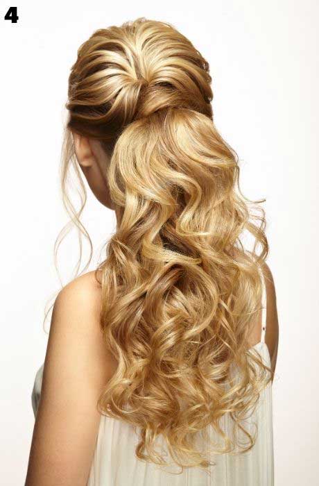 Blonde model showcases curled low ponytail wedding hairstyle.