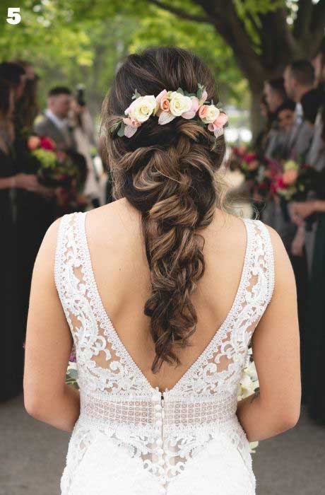Bride with a twisted, loose braid wedding hairstyle and flower pin accessory. o	wedding hairstyle.