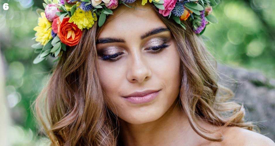 Bride wears colorful flower crown and has loose curly hair.