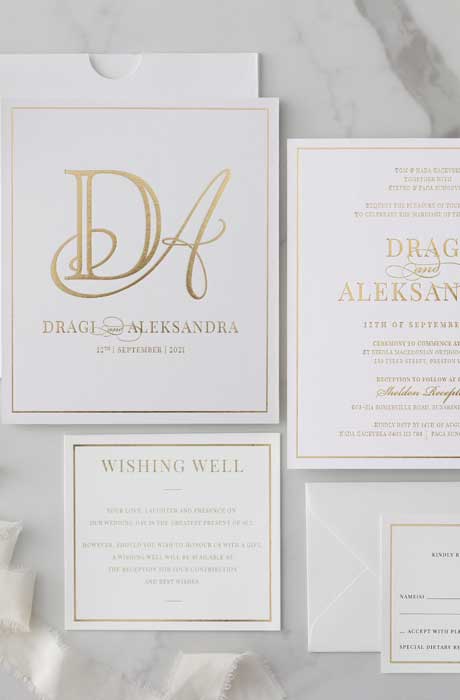 A monogram white and gold wedding invitation suite by Giant Invitations. 