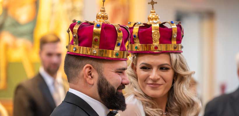 Bride and Groom during their ceremony wearing King and Queen crowns. 
