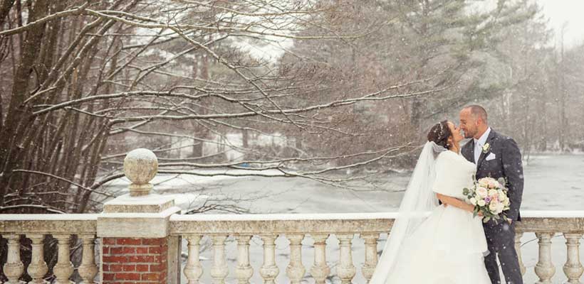 Bride and Groom kissing during winter on a bridge. 