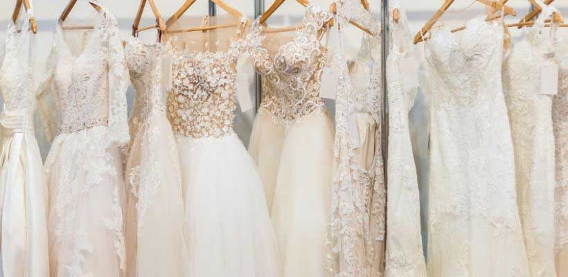 Various wedding gowns on a rack. 