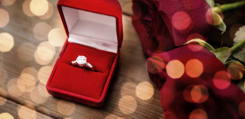 Engagement ring in a small red box. 