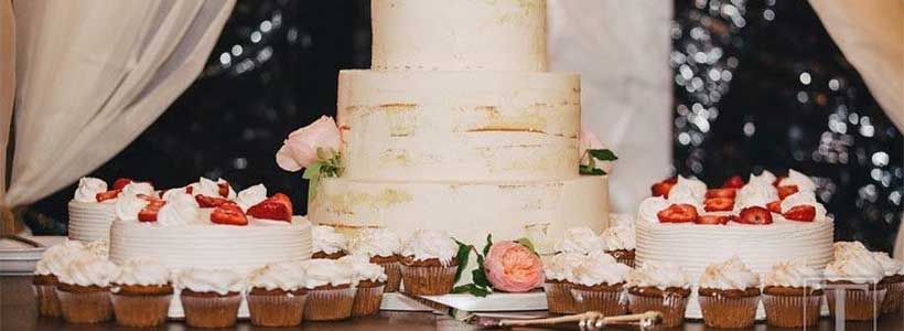 Wedding cakes and cupcakes beautifully displayed on a table.