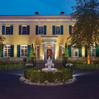 Front entrance and exterior of The Mansion at Oyster Bay with a fountain.