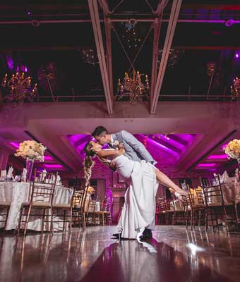 Bride and groom on dance floor at Fox Hollow with purple uplightinhg. 
