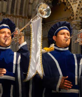 Two ceremonial trumpeters in blue renaissance costumes.