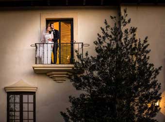 Couple standing on a balcony at Village Club at Lake Success. 